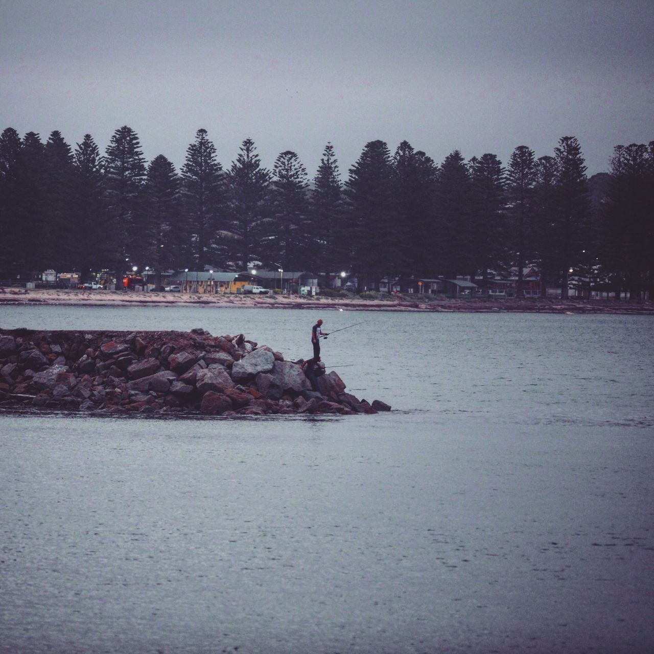 旁边的渔人还在等待渔获