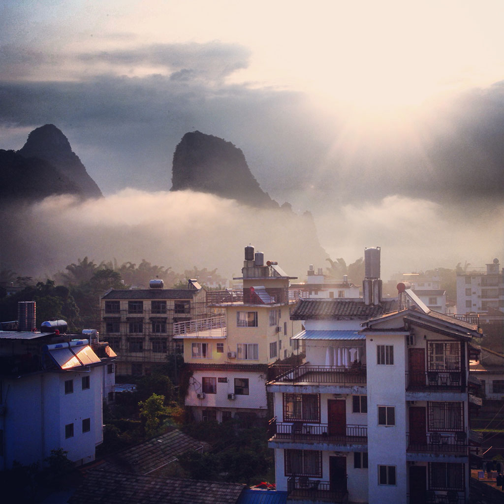 次日清晨，薄雾下的小村，阳光从中窜出